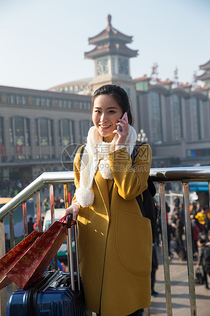 春运东方人拿着青年女人在站前广场图片