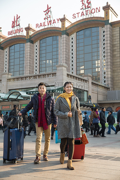 离开旅行者围巾青年男女在站前广场图片