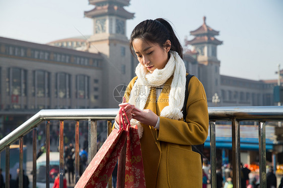 东亚手机旅途青年女人在站前广场图片