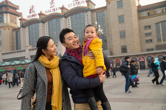 女人户外行李幸福家庭在站前广场图片