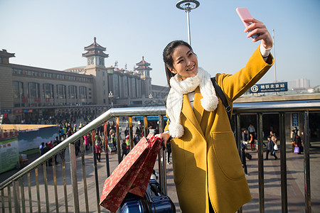 过年背包客公共交通青年女人在站前广场图片