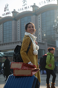 旅行箱东亚幸福青年女人在站前广场图片