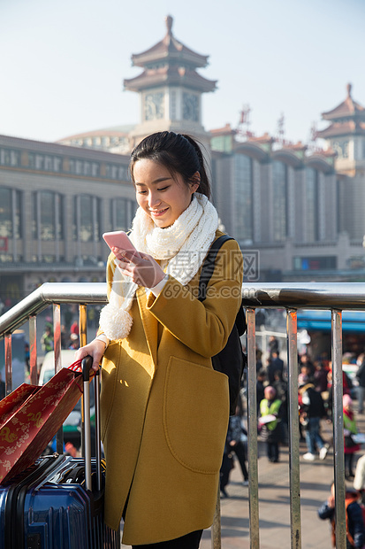 手机春运青年女人在站前广场图片