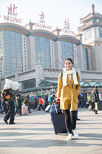 过年旅行者前景聚焦青年女人在站前广场图片