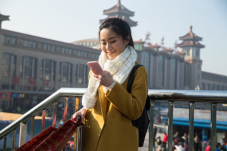 乘客春运旅行青年女人在站前广场图片