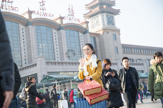 东方人拿着亚洲人青年女人在站前广场图片