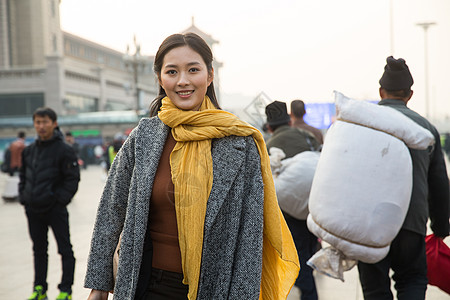 美女围巾旅行的人摄影春运青年女人在站前广场背景