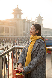 火车围巾前景聚焦青年女人在站前广场图片