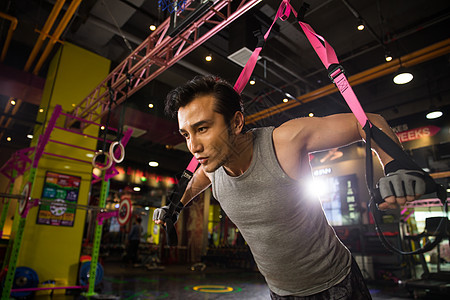 健康灯光锻炼青年男人在健身房里健身图片