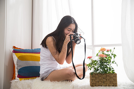 青年女人拿着相机拍照图片