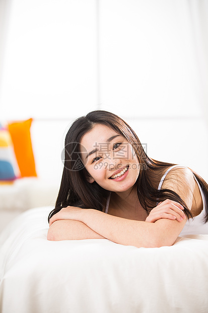 欢乐放松背心青年女人趴在床上图片