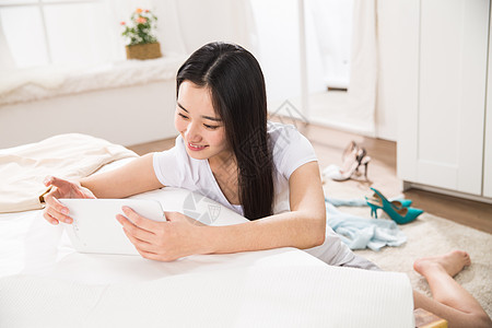 东亚户内活力青年女人看平板电脑图片