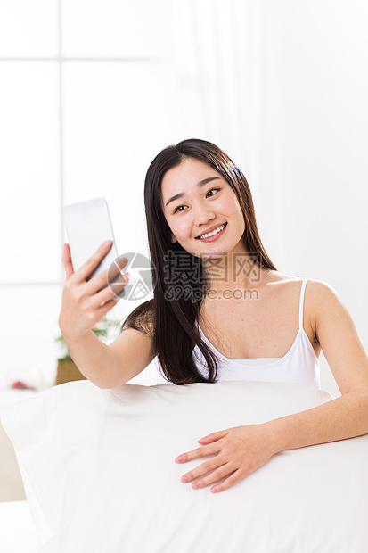 垂直构图20到24岁手机青年女人在卧室自拍图片