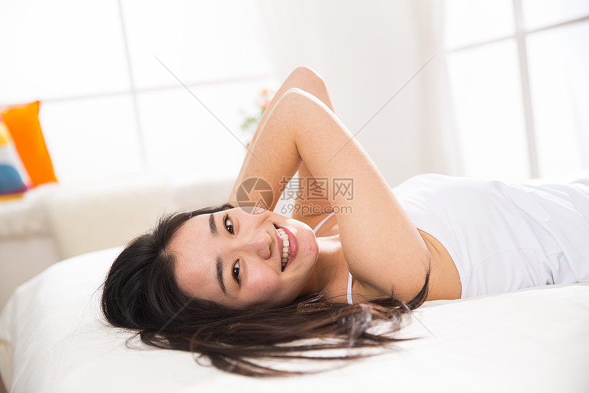起床彩色图片摄影青年女人在卧室的床上图片