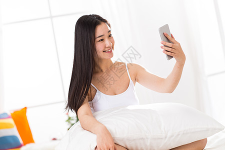 手机东方人活力青年女人在卧室自拍图片