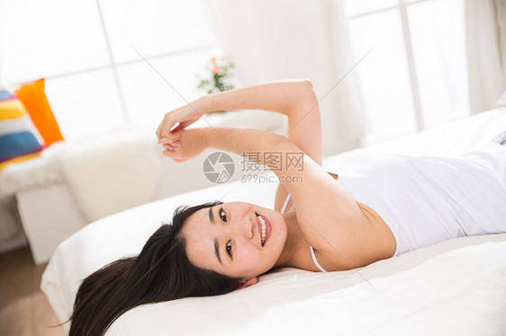 惬意享乐躺着青年女人在卧室的床上图片