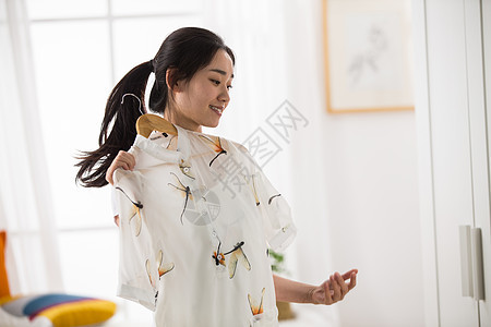 美女欢乐衣架青年女人试衣服图片