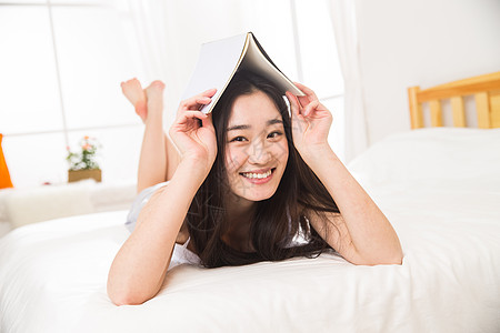 床东方人享受青年女人看书图片