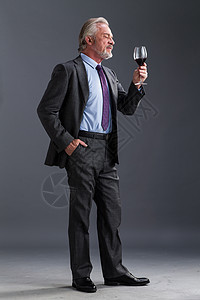垂直构图黑色背景红酒权威商务老年男人图片