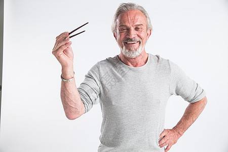 乐趣成就影棚拍摄老年男人拿着筷子图片