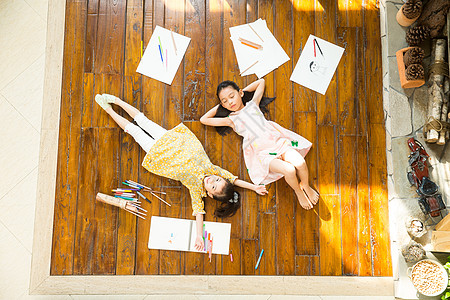住宅房间姐妹俩躺在地板上玩耍图片