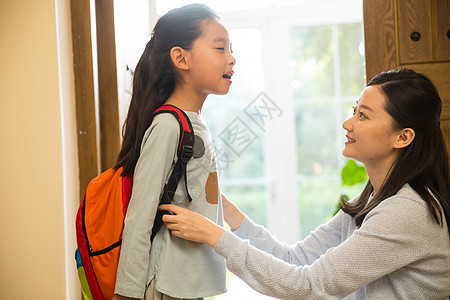 休闲学生门口妈妈送女儿去上学图片