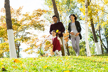 孕妇小孩高兴的秋天树幸福家庭在户外玩耍背景