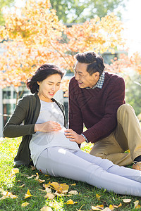 休闲女人白昼丈夫陪着怀孕的妻子在户外图片