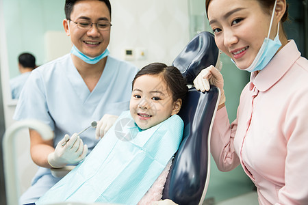 医疗工具东方人护士男牙医和女牙医助手在为小女孩检查牙齿图片