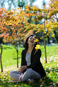 花瓣和树叶好奇心度假季节青年女人在户外背景