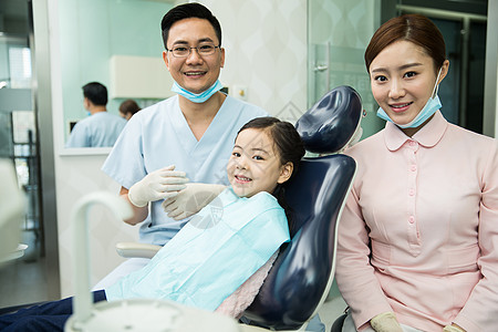 卫生口腔医学服务男牙医和女牙医助手在为小女孩检查牙齿图片