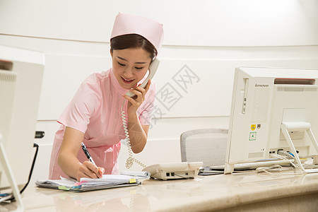 医院年轻女护士在接待处接听电话图片