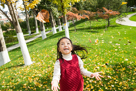 高兴的落叶东方人可爱的小女孩在户外玩耍图片