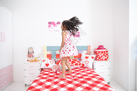 高兴的无忧无虑休闲可爱的小女孩在卧室玩耍图片