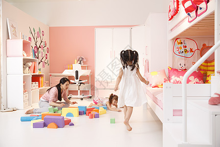 柔和混血儿享乐青年女人和两个女孩在卧室玩耍图片