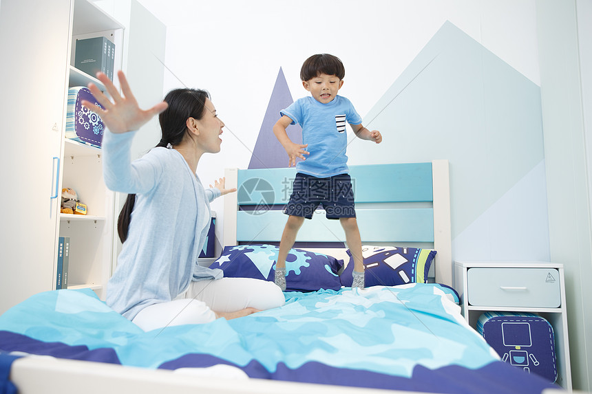 家居床天真可爱的小男孩和妈妈在卧室玩耍