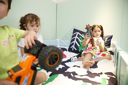 东方人摄影人欢乐的儿童在床上玩耍图片