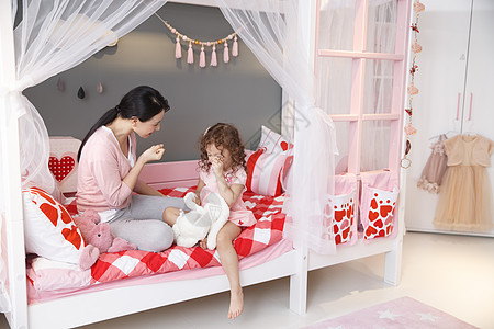 人床中年女人可爱的小女孩和妈妈在卧室玩耍图片
