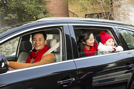 透过窗户往外看可爱的幸福家庭坐在汽车里图片