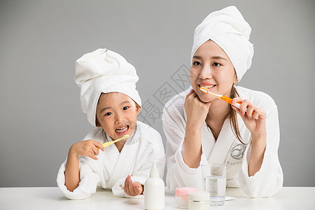 浴巾天真浴衣穿着浴袍的母女刷牙图片