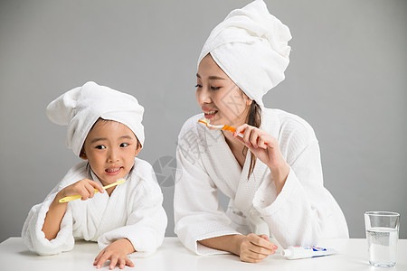 水平构图休闲装浴巾穿着浴袍的母女刷牙图片