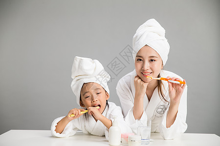 牙刷毛巾东亚20到24岁人穿着浴袍的母女刷牙背景
