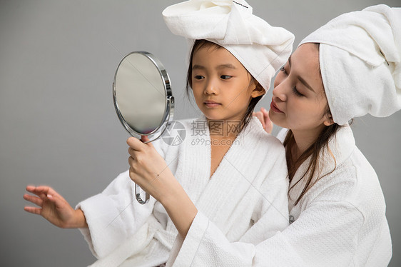 微笑女儿穿着浴袍的母女照镜子图片