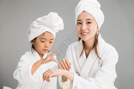 玩耍母亲协助穿着浴袍的母女图片