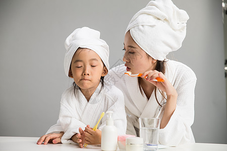 学龄前儿童无忧无虑摄影穿着浴袍的母女刷牙图片