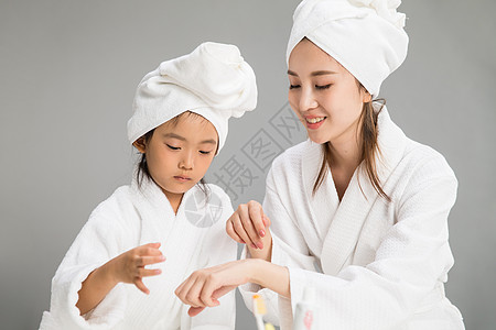 灰色背景乐趣穿着浴袍的快乐母女图片