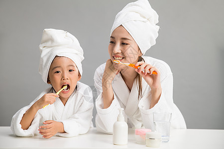 家庭生活幸福独生子家庭穿着浴袍的母女刷牙图片