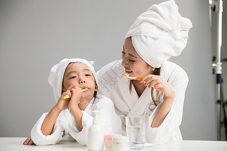 水平构图女人住宅房间穿着浴袍的母女刷牙图片