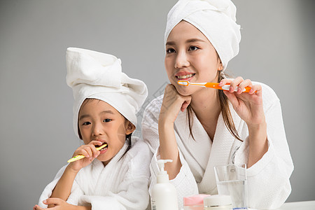 享乐口腔卫生独生子家庭穿着浴袍的母女刷牙图片