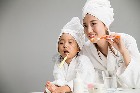 一致母亲健康生活方式穿着浴袍的母女刷牙图片